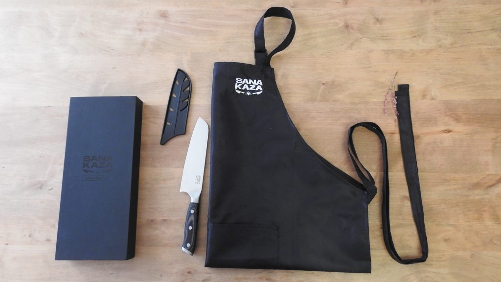 Pack Sanakaza comprenant un couteau japonais Santoku , son fourreau et un tablier de cuisine noir unisexe.