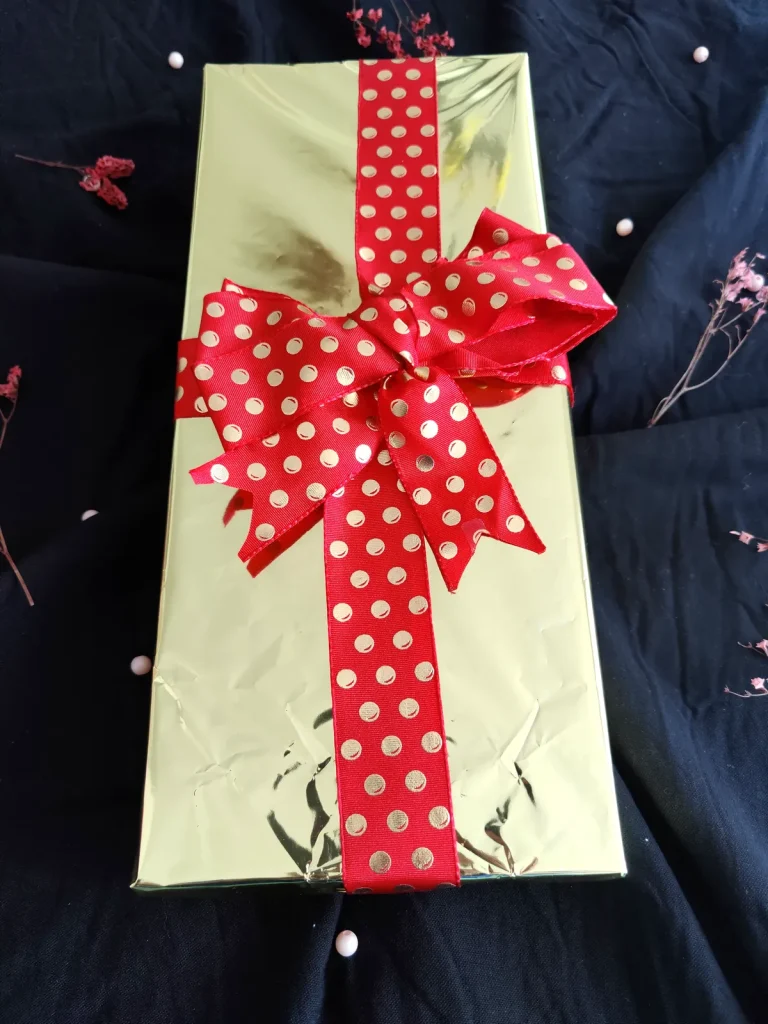 Coffret cadeau Sanakaza emballé en doré avec ruban rouge à pois