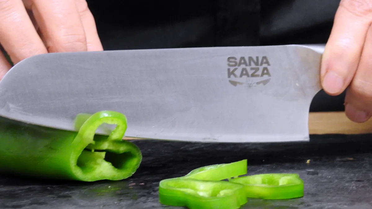 Découpe d'un poivron vert avec le couteau Santoku Sanakaza en toute sécurité